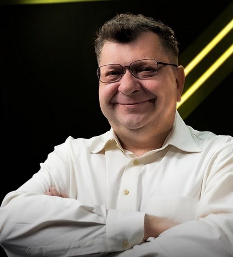 Zbigniew Stonoga podczas publicznego wystąpienia, z charakterystycznym, intensywnym spojrzeniem, w tle sugerującym wydarzenie medialne.