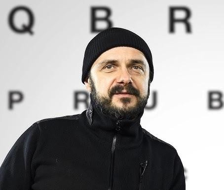 Arkadiusz Jakubik jako wokalista zespołu Dr Misio, podczas energicznego występu na scenie.