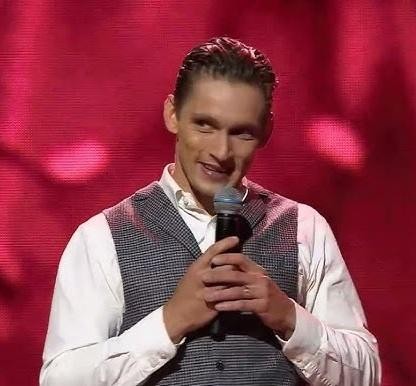Filip Gurłacz w dynamicznej pozie tanecznej na scenie, w stroju do tańca, z widoczną energią i prezencją.