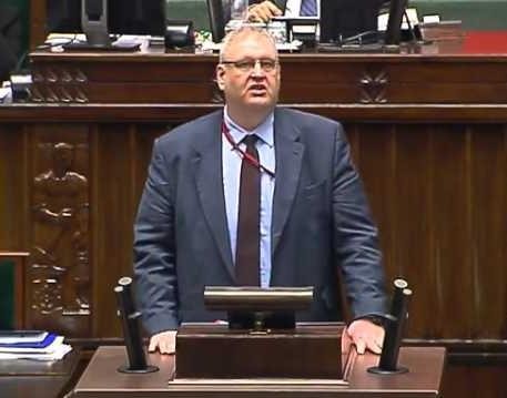 Bogdan Święczkowski w dynamicznej pozie, symbolizującej jego bezkompromisowy styl zarządzania i przydomek „Godzilla”.