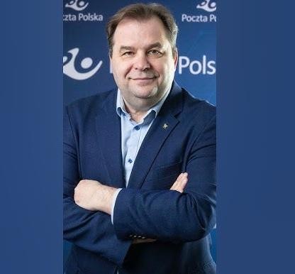 Sebastian Mikosz, prezes zarządu Poczty Polskiej, w dynamicznej pozie, symbolizującej jego rolę jako lidera i menedżera, z elementami lotnictwa lub korporacji w tle.