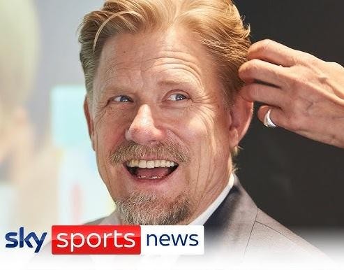 Peter Schmeichel jako komentator sportowy, z uśmiechem i gestykulacją, w tle studia telewizyjnego, symbolizujący jego aktywność po zakończeniu kariery piłkarskiej.
