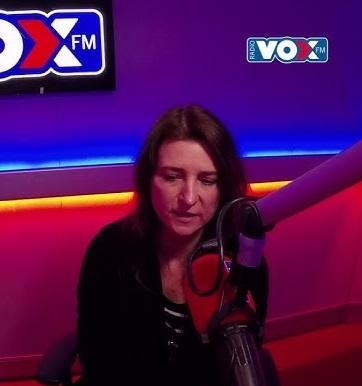Renata Dąbkowska śpiewająca na scenie podczas koncertu, z mikrofonem w dłoni i dynamicznym oświetleniem.