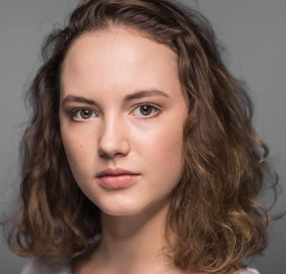 Martyna Byczkowska na nowoczesnym planie filmowym, w stylowym stroju, emanująca pewnością siebie i profesjonalizmem.