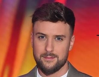 Aleksander Sikora, polski prezenter telewizyjny, w naturalnej pozie, ukazującej jego charyzmę i profesjonalizm.