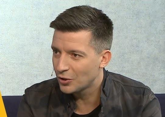 Michał Cessanis prowadzący prelekcję o podróżowaniu kamperem po Australii Zachodniej, wskazujący na ekran z widokiem na kamper i krajobraz.