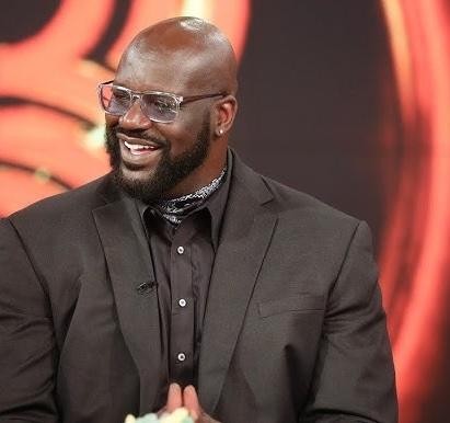 Shaquille O'Neal podczas meczu NBA, wykonujący efektowną akcję pod koszem.