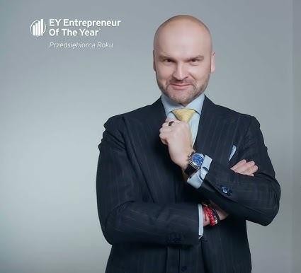 Rafał Brzoska przedstawiający innowacyjne rozwiązania InPost w nowoczesnym otoczeniu biurowym lub centrum logistycznym.