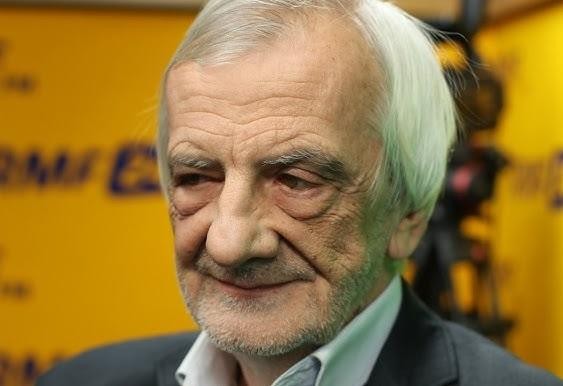 Ryszard Terlecki podczas wystąpienia publicznego, z widoczną determinacją, w tle rozmazane elementy sugerujące salę plenarną Sejmu.