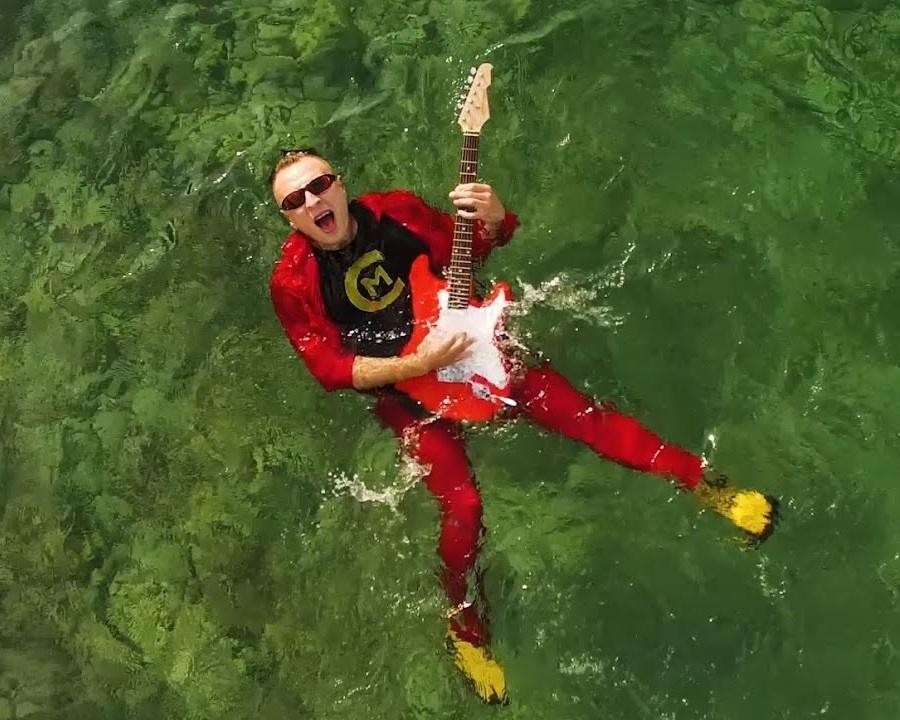 Czadoman podczas energetycznego występu na scenie, otoczony dynamicznym oświetleniem.