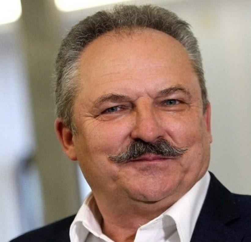 Marek Jakubiak podczas wystąpienia publicznego, z mikrofonem w dłoni.