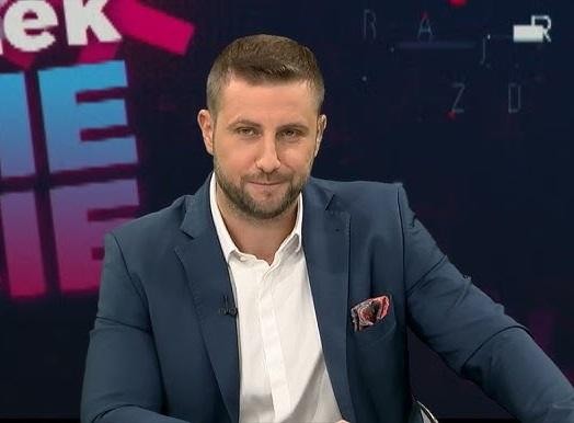 Miłosz Kłeczek podczas ostrej wymiany zdań w studiu telewizyjnym, gestykulujący, z napiętą mimiką.