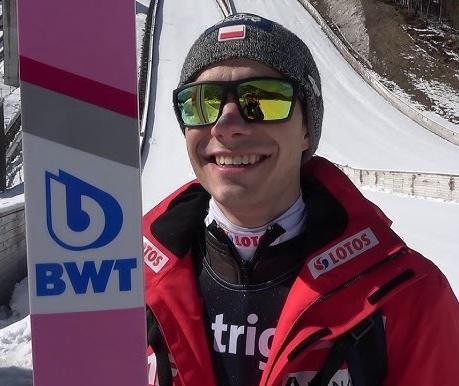 Jakub Wolny w trakcie skoku, z widocznym skupieniem na twarzy i dynamiczną postawą.